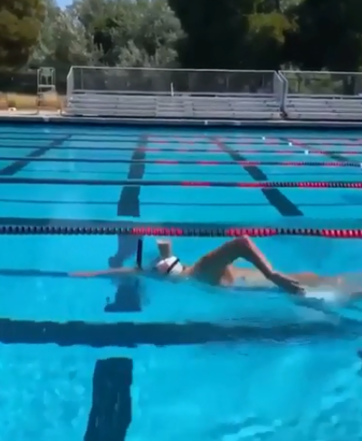 Katie Ledecky, swims with a glass of chocolate milk on her head